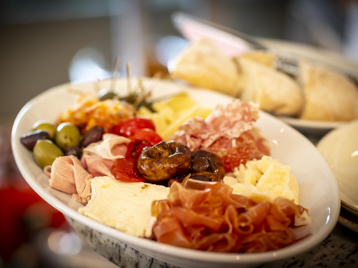 Schön angerichteter Teller mit Wurst, Käse und Oliven