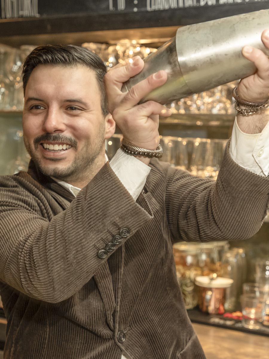 Mann mixt einen Cocktail an der Theke