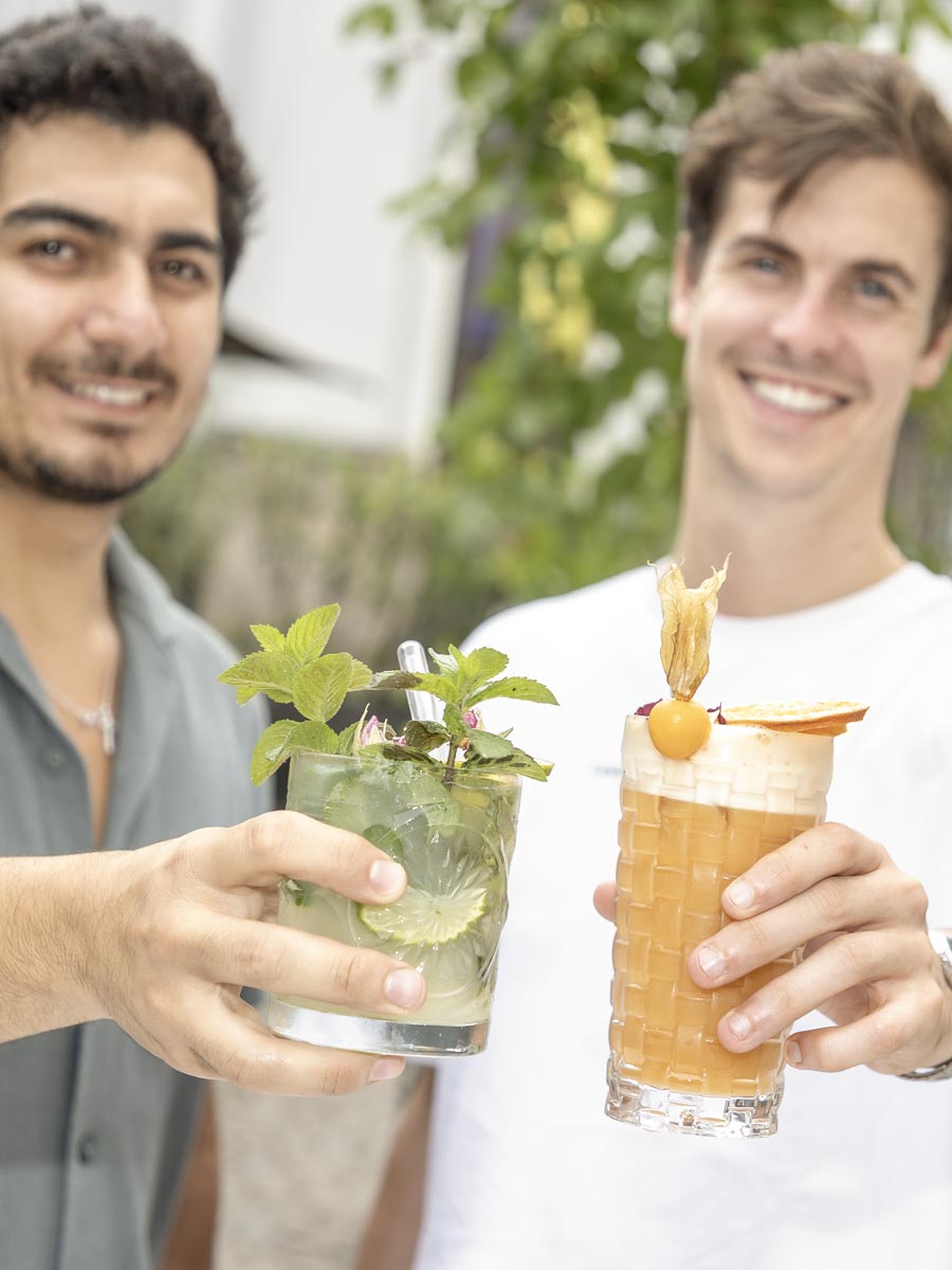Zwei Männer halten jeweils einen Cocktail